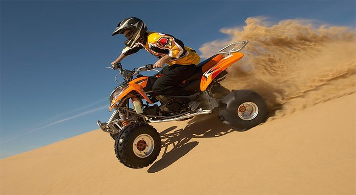 Experience the rush of gliding over golden sand dunes on an ATV capturing stunning desert views while enjoying the morning sun in Dubai’s breathtaking landscape.